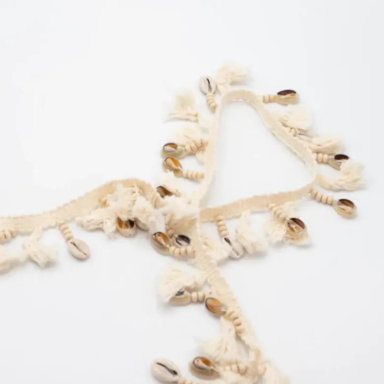 Frange à pompons et coquillages
