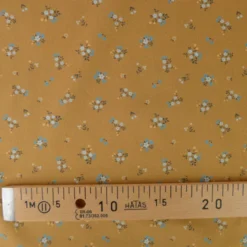 Popeline de coton Bisou motif fleurs bleues fond Ocre