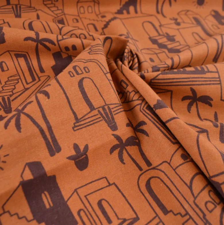 Tissu demi-natté imprimé médina maisons et palmiers fond caramel
