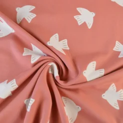 Tissu French Terry coton – Motif oiseaux fond rose corail - OEKO TEX