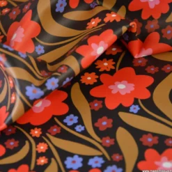 Tissu imperméable Beyoncé type ciré de pluie motif fleurs rouges fond cacao