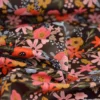 Tissu imperméable Olga type ciré de pluie motif fleurs rouges fond cacao
