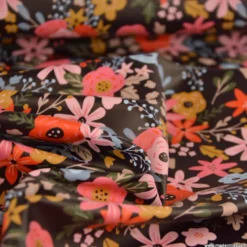 Tissu imperméable Olga type ciré de pluie motif fleurs rouges fond cacao