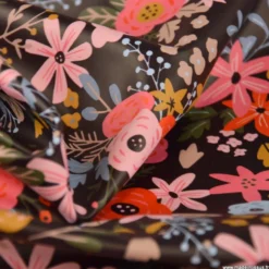 Tissu imperméable Olga type ciré de pluie motif fleurs rouges fond cacao