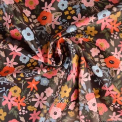 Tissu imperméable Olga type ciré de pluie motif fleurs rouges fond cacao