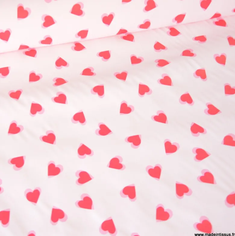 Tissu imperméable Popheart type ciré de pluie motif coeurs fond rose pale