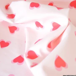 Tissu imperméable Popheart type ciré de pluie motif coeurs fond rose pale