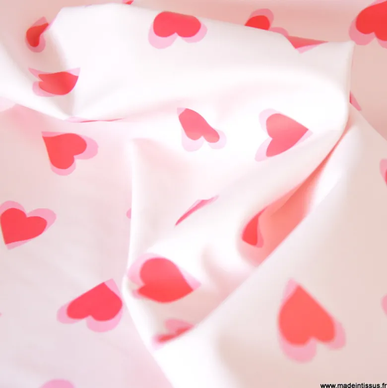 Tissu imperméable Popheart type ciré de pluie motif coeurs fond rose pale