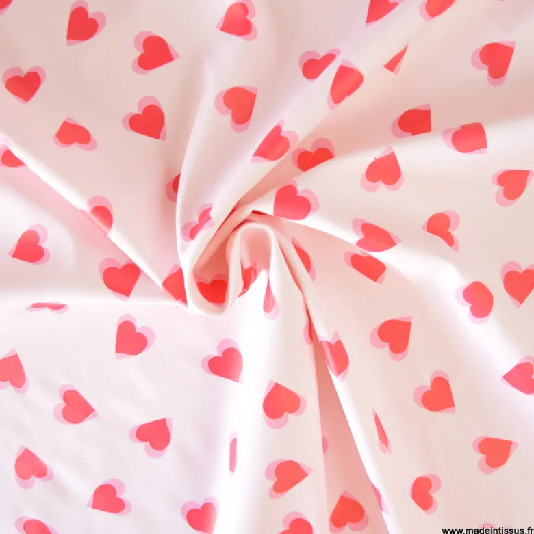 Tissu imperméable Popheart type ciré de pluie motif coeurs fond rose pale
