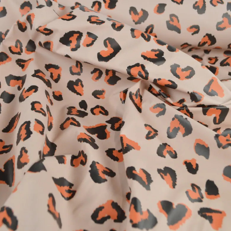 Tissu imperméable Saian type ciré de pluie motif léopard coeurs fond galet