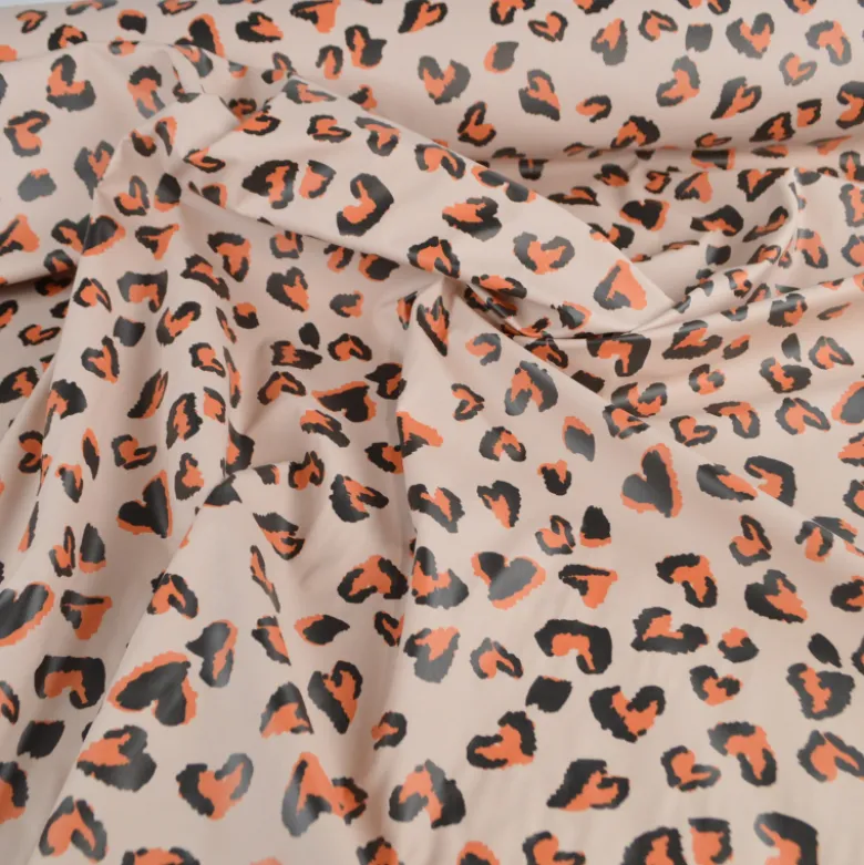 Tissu imperméable Saian type ciré de pluie motif léopard coeurs fond galet