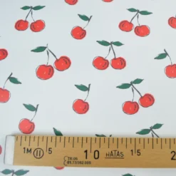 Tissu imperméable type ciré motif cerises fond blanc