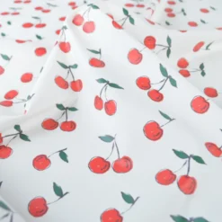 Tissu imperméable type ciré motif cerises fond blanc