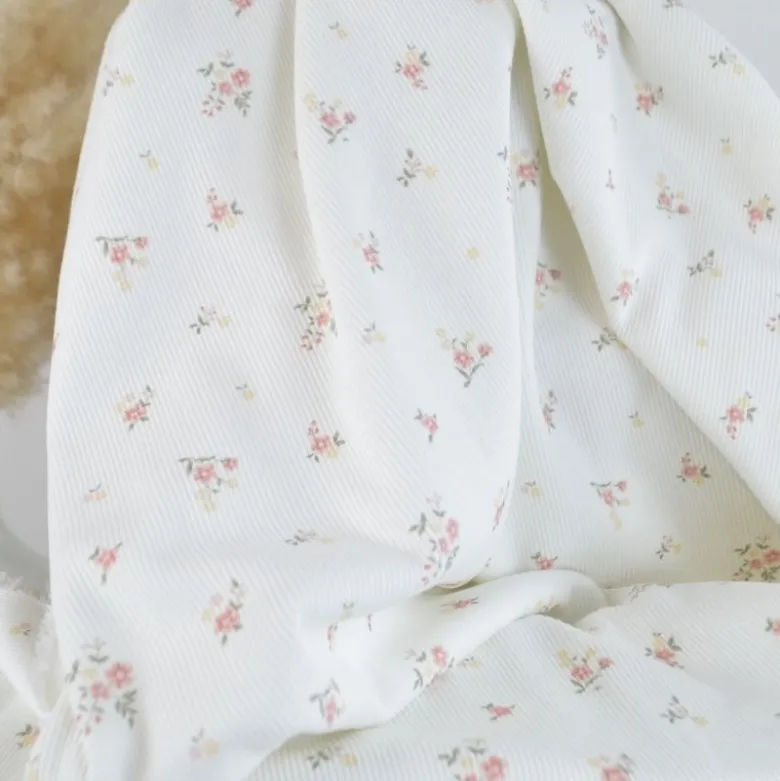 Tissu jersey côtelé motif fleurs roses fond blanc cassé