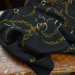 Tissu Jersey milano motif chaines dorés fond noir