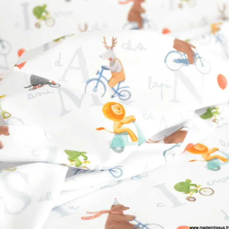 Tissu jersey motif animaux faisant du vélo fond blanc