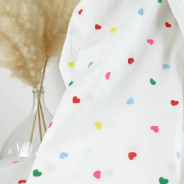 Tissu popeline de coton brodée coeurs multicouleurs