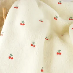 Tissu Sherpa brodée motif cerises fond écru