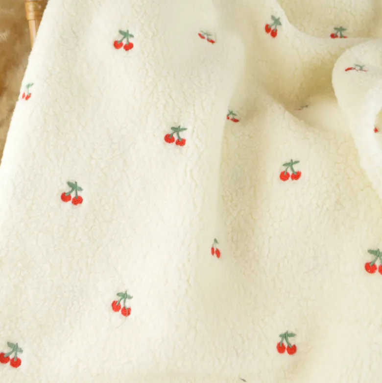 Tissu Sherpa brodée motif cerises fond écru