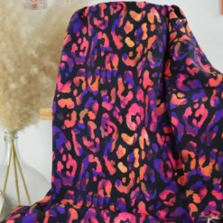 Tissu viscose motif léopard rose orange fond noir
