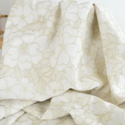 Tissu voile de coton brodé beige motif fleurs fond sable