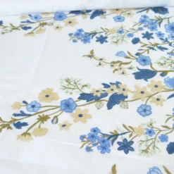 Voile de coton brodé de fleurs bleues et beige fond blanc