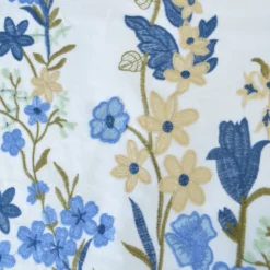 Voile de coton brodé de fleurs bleues et beige fond blanc