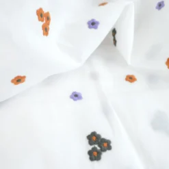 Voile de coton brodé de petites fleurs camel fond blanc